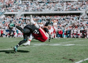 football player tackled other player during daytime
