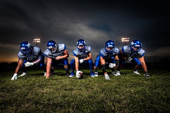 Football Players in Blue Jersey Lined Under Grey White Cloudy Sky during Sunset · Free Stock Photo