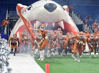 Football Team Running Thru Football Field