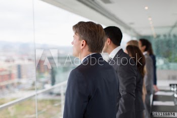 Forward looking business people at office window