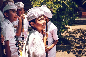 Four Boys Wearing White Hats Holding Spears