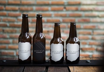 Four Brown Labeled Glass Bottles on Wooden Surface