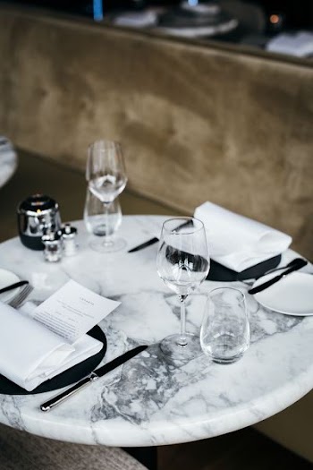 four clear drinking glasses on top of round white marble table