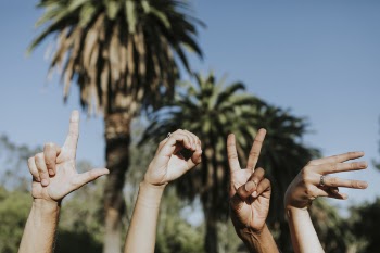 Four Hands Doing Love Signs