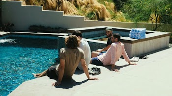 Four Men Sitting Beside Swimming Pool