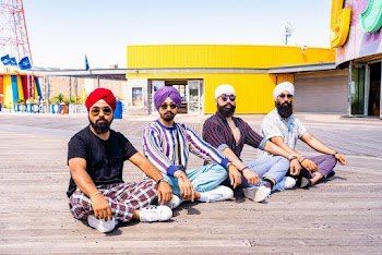 Four Men Sitting on Boardwalk