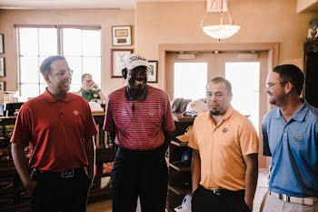 Four Men Wearing Assorted-color Polo Shirts Standing Inside Room