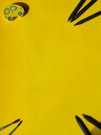 Four Pens and Two Paint Brushes on Yellow Surface With Eraser