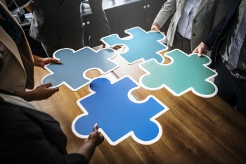 Four People Holding Blue Puzzles