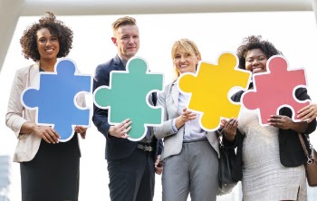 Four People Holding Puzzles Pieces