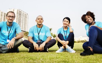 Four People Sitting On Grass