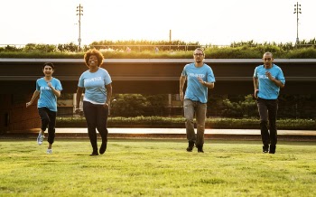 Four People Standing on Green Grass Field
