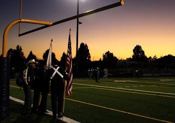 Four People Standing Under on Football Goal during Sunrise