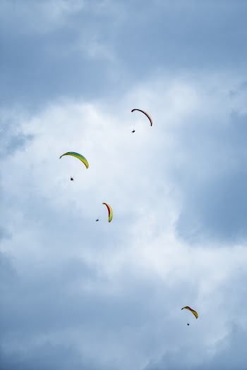 Four Person Parachuting Under Cloudy Sky