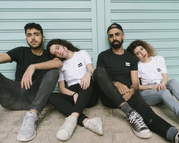 Four Person Sitting on Floor Leaning on Shutter Door