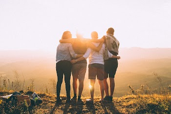 Four Person Standing on Cliff in Front of Sun · Free Stock Photo