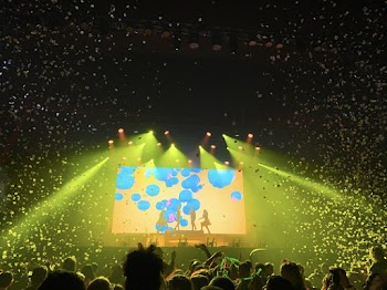 Four Person Standing on Stage in Front of People