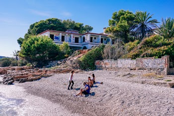 Four Persons on Shore Near House