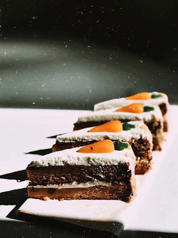 Four Slices of Vanilla Chocolate Cakes on White Surface