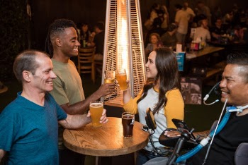Four Smiling People Beside Table With Drinks