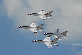 four white jet planes flying during daytime