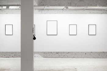 four white wall photo frames in room