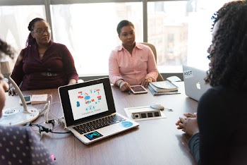 Four Women Sitting on Chair and Taking Talk over