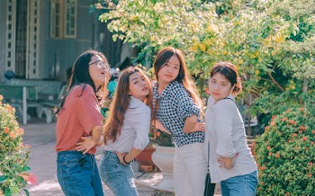 Four Women Standing Near Plants Taken