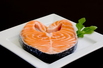 fresh salmon slice on white platter with salad