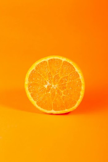 Freshly Sliced Orange on Vibrant Orange Background