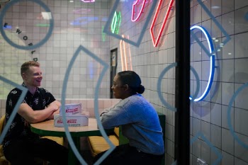 Friends having fun talking to each other under neon lights.