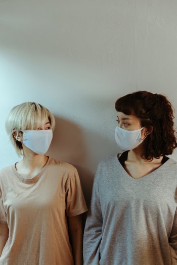 Friends in face masks looking at each other