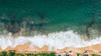 From Above Photo Of Waves Breaking On The Shore Of The Clear Ocean Water