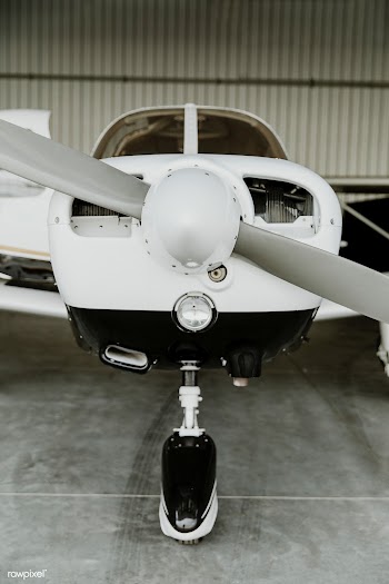 Front propellor plane parked in a hangar