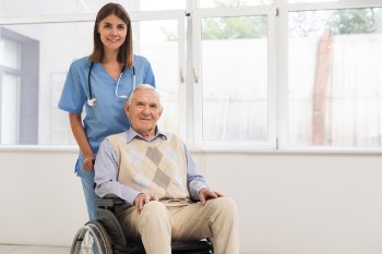 Front view nurse and old man looking at the camera Free Photo