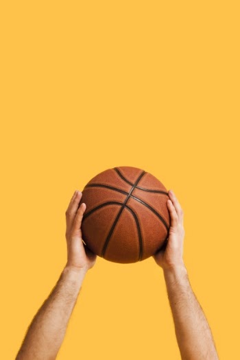 Front view of basketball held up by male player Free Photo