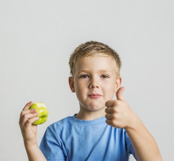 Front young boy with a green apple Free Photo