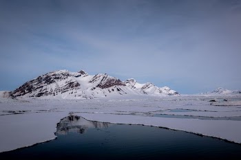 frozen lake and land formation photo during daytime