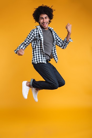 Full length portrait of a happy young african man jumping Free Photo