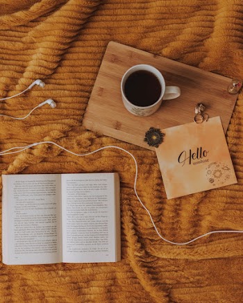 Full Mug on Wooden Cutting Board and White Book Pages