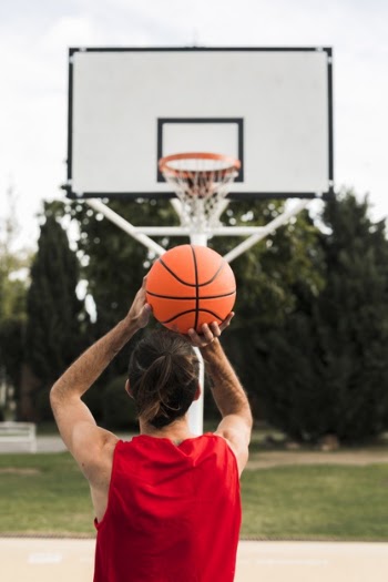 Full shot of boy throwing in the basketball hoop Free Photo