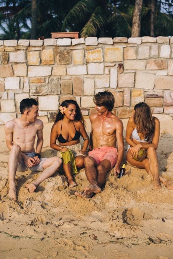 Full Shot of Friends Sitting on Sand