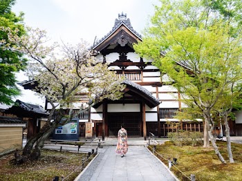 Geisha Walking Towards White Building