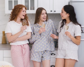 Girfriends having a drink at pijama party Free Photo