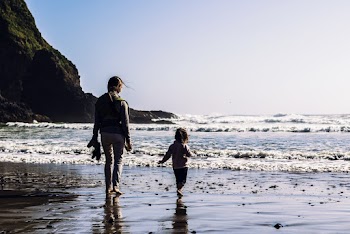 Girl and Toddler Walking at the Shore