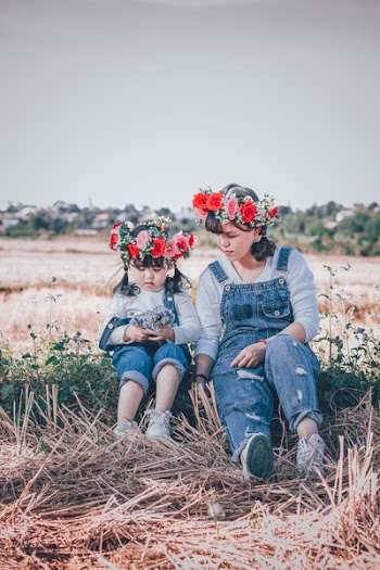 Girl And Woman Sitting On Ground Near Rice Paddy
