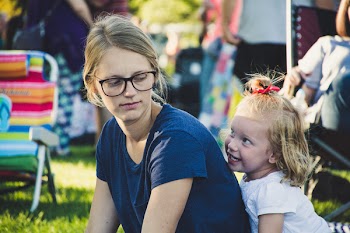 Girl Behind Woman Near Folding Chair