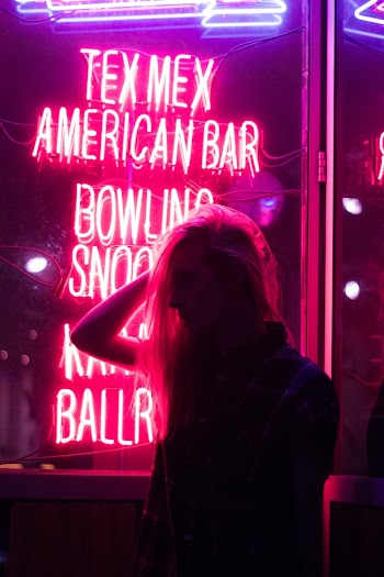 Girl Holding Her Hair Near the Neon Light Signage