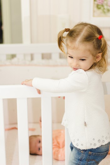 Girl Holding Standing on Crib