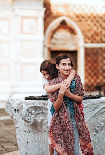 girl hugging girl wearing maroon scarf